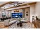 Elegant living room with stylish decor, wood beam ceilings, and an open view to the dining area at 13726 Heartwood Way, Parrish, FL 34219