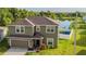 Charming two-story home features a landscaped yard with a lake view and attached two-car garage at 14560 Haddon Mist Dr, Wimauma, FL 33598