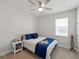 This is a bedroom featuring light carpet, a ceiling fan, bright window, side table, and blue bedding at 152 Bright Ibis Ave, Apollo Beach, FL 33572
