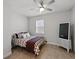 This is a cozy bedroom featuring patterned bedding, a ceiling fan, tile floors, and a modern Sanyo TV at 152 Bright Ibis Ave, Apollo Beach, FL 33572