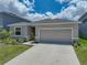 A single Gathering home has a grey shingle roof, stone accents, and well-kept lawn at 152 Bright Ibis Ave, Apollo Beach, FL 33572