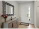 A nicely decorated foyer features a grey buffet table and a large mirror at 152 Bright Ibis Ave, Apollo Beach, FL 33572