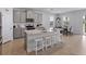 Spacious kitchen features an island, grey cabinetry, stainless steel appliances, and barstool seating at 152 Bright Ibis Ave, Apollo Beach, FL 33572