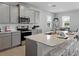 Bright open kitchen with gray cabinetry, stainless appliances, and dining area with natural light at 152 Bright Ibis Ave, Apollo Beach, FL 33572