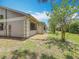 A rear view shows the back of the house with a manicured lawn and trees at 1556 Lynda Ln, Dunedin, FL 34698