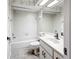 An all-white bathroom features a vanity, toilet and tiled shower/tub at 1556 Lynda Ln, Dunedin, FL 34698