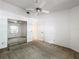 A bright bedroom features a ceiling fan, closet with mirrored doors and neutral carpet at 1556 Lynda Ln, Dunedin, FL 34698