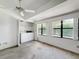 Bright bedroom features in-unit laundry, ceiling fan, and large windows at 1556 Lynda Ln, Dunedin, FL 34698