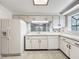 Bright eat-in kitchen featuring white cabinets and stainless steel appliances at 1556 Lynda Ln, Dunedin, FL 34698