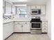 Kitchen featuring white cabinets and stainless steel appliances at 1556 Lynda Ln, Dunedin, FL 34698