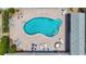 Overhead view of a luxurious backyard swimming pool with lounge chairs and tables on a brick patio at 1556 Lynda Ln, Dunedin, FL 34698