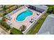 Aerial view of a backyard pool area with chairs and tables, surrounded by a privacy fence at 1556 Lynda Ln, Dunedin, FL 34698