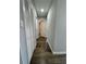 Hallway with wood-look flooring and gray walls, showcasing closet and access to other rooms at 1675 13Th S Ave, St Petersburg, FL 33712