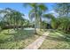 Inviting backyard with a freeform pool surrounded by lush landscaping and a covered patio, ideal for outdoor living at 1813 Nova Dr, Valrico, FL 33596