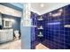 Modern bathroom featuring blue tile, shelving, and updated fixtures at 1813 Nova Dr, Valrico, FL 33596
