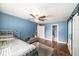 Cozy bedroom with a ceiling fan, wood floors, and view of an ensuite bathroom at 1813 Nova Dr, Valrico, FL 33596