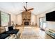 Cozy living room with a stone fireplace, vaulted ceiling, and wood-look tile flooring at 1813 Nova Dr, Valrico, FL 33596