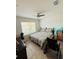 Cozy bedroom with ceiling fan, window, and tile flooring, offering comfort and functionality at 18292 Hunters Meadow Walk, Land O Lakes, FL 34638