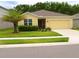 Inviting single-story home with a well-manicured lawn, lovely landscaping and a sunny yellow facade at 18292 Hunters Meadow Walk, Land O Lakes, FL 34638