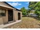 Backyard view features two doors, partial fencing and mature trees at 1920 E Chelsea St, Tampa, FL 33610