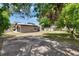 Backyard view of the house with trees and a concrete parking pad at 1920 E Chelsea St, Tampa, FL 33610