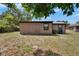 Backyard view of house with trash cans, grass and chain link fence at 1920 E Chelsea St, Tampa, FL 33610