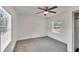 Bright bedroom features neutral paint, a ceiling fan, and a large window bringing in natural light at 1920 E Chelsea St, Tampa, FL 33610