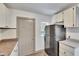 Bright kitchen featuring white cabinets, appliances, and a door at 1920 E Chelsea St, Tampa, FL 33610