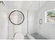 Clean and modern bathroom with a glass-enclosed shower, a toilet, and a round mirror at 2015 3Rd S St, St Petersburg, FL 33705