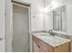 Well-lit bathroom with a granite countertop vanity and a glass-enclosed shower at 219 Pompano Se Dr # C, St Petersburg, FL 33705