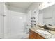 Bathroom featuring a shower-tub combo, granite countertop, decorative shelves, and tiled walls at 219 Pompano Se Dr # C, St Petersburg, FL 33705
