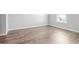 Bright bedroom featuring stylish wood-look flooring and a window with natural light at 219 Pompano Se Dr # C, St Petersburg, FL 33705