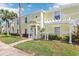 Charming yellow condo with white trim, shutters, and pergola entrance, complemented by lush landscaping and palm trees at 219 Pompano Se Dr # C, St Petersburg, FL 33705