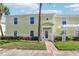 Inviting yellow condo with white accents, shutters, and a pergola, set amid well-maintained greenery and a blue sky at 219 Pompano Se Dr # C, St Petersburg, FL 33705