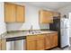 Modern kitchen featuring granite countertops, stainless steel appliances, and wooden cabinets at 219 Pompano Se Dr # C, St Petersburg, FL 33705