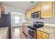 Modern kitchen featuring granite countertops, stainless steel appliances, and wooden cabinets at 219 Pompano Se Dr # C, St Petersburg, FL 33705