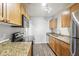 Modern kitchen featuring granite countertops, stainless steel appliances, and wooden cabinets at 219 Pompano Se Dr # C, St Petersburg, FL 33705