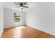 Bright bedroom featuring hardwood floors, a ceiling fan, and a window offering natural light at 2313 Palm Ave, Seffner, FL 33584