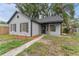 Charming home exterior with gray siding, black trim, and well-maintained landscaping at 2313 Palm Ave, Seffner, FL 33584