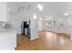 Open-concept living area with hardwood floors, modern lighting, and stainless steel kitchen appliances at 2313 Palm Ave, Seffner, FL 33584