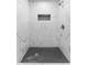 Elegant shower with marble-patterned walls and a contrasting black tile floor at 2313 Palm Ave, Seffner, FL 33584