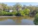 This backyard view shows the house next to a creek with mature trees offering natural privacy at 2416 S 46Th St, Tampa, FL 33619