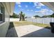 Enclosed backyard with white fencing, a small patio, and a unique tree trunk feature at 2830 Anthony St, Tampa, FL 33619