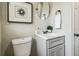 Bathroom featuring a gray vanity, toilet, artwork, and modern decor at 2830 Anthony St, Tampa, FL 33619