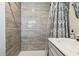 Modern bathroom with gray tile shower, new shower head, sleek vanity, and stylish shower curtain at 2830 Anthony St, Tampa, FL 33619