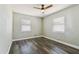 Bright bedroom featuring wood-look floors, neutral paint, and two windows at 2830 Anthony St, Tampa, FL 33619