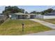Well-maintained home with a carport, complemented by a green lawn and blue skies at 2830 Anthony St, Tampa, FL 33619