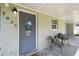 Charming covered porch featuring a cozy seating area and a detailed front door at 2830 Anthony St, Tampa, FL 33619