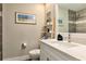 Bright bathroom featuring a vanity, decorative shelving, and shower with tiled walls at 3282 Mangrove Point Dr, Ruskin, FL 33570