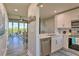 Modern kitchen featuring white cabinetry and stainless steel appliances, open to the dining and living area at 3282 Mangrove Point Dr, Ruskin, FL 33570